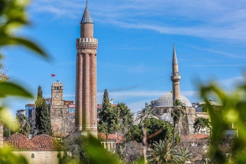 A historic building with a tall minaret and a dome, surrounded by trees and other structures. 1