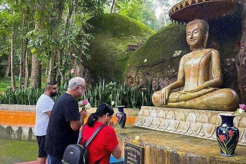 A large seated Buddha statue surrounded by visitors. 2