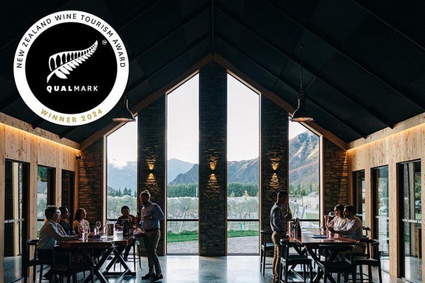 A restaurant with large windows, wooden interior, and a mountain view. 2