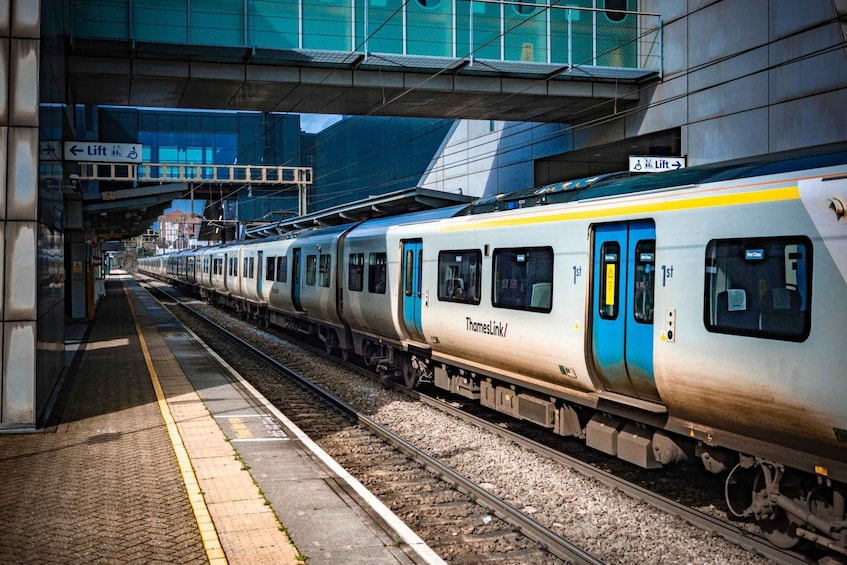 A train at a station with a lift sign overhead. 1
