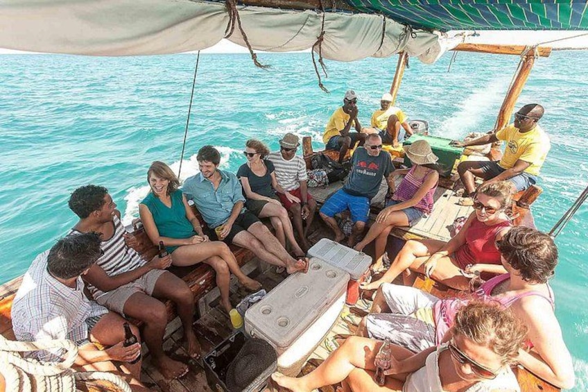A group of people on a boat with a canopy, sitting and socializing. 3
