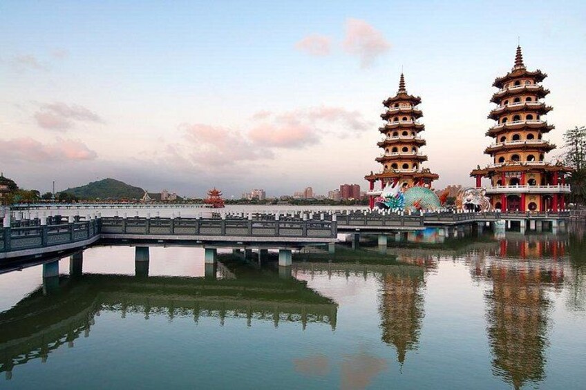 A calm lake with two pagoda-style buildings and a bridge. 3
