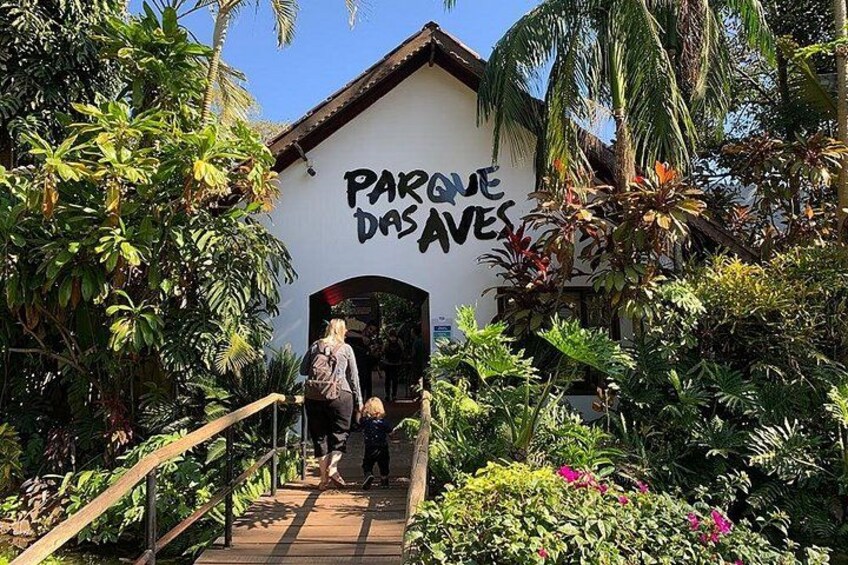En sti, der fører til en bygning med et skilt, der siger 'PARQUE DAS AVES'. 5