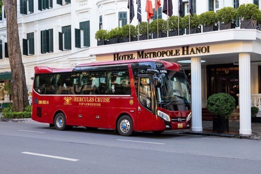 Un autobús rojo con la leyenda 'Hercules Cruise VIP Limousine' estacionado frente al Hotel Metropole Hanoi. 4