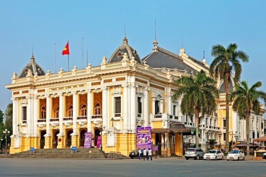 Un edificio imponente con arquitectura clásica, una bandera y palmeras. 3