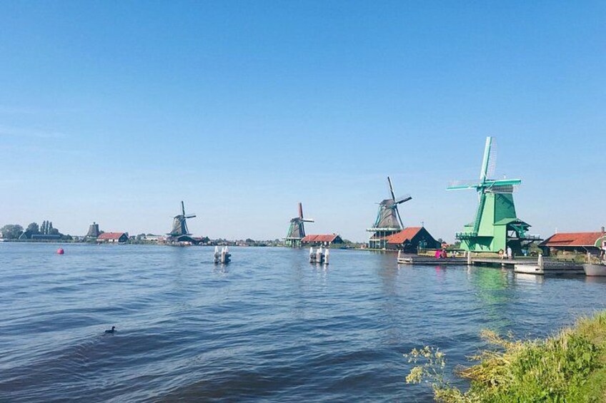 Un plan d’eau paisible, avec des moulins à vent et des bateaux. 2