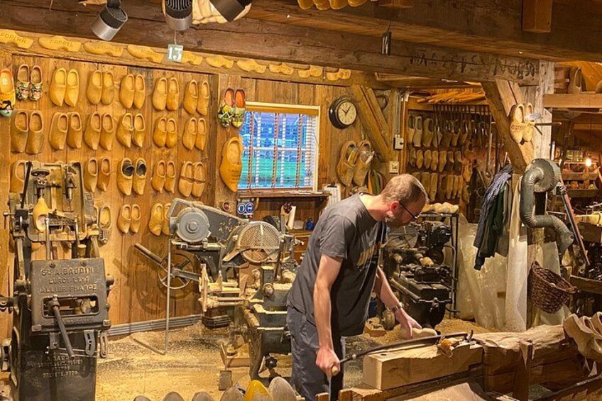 Un atelier équipé d’outils de travail du bois et de présentoirs pour chaussures. 3