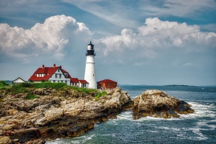 A lighthouse, a red-roofed house, and rocky coastline. 4