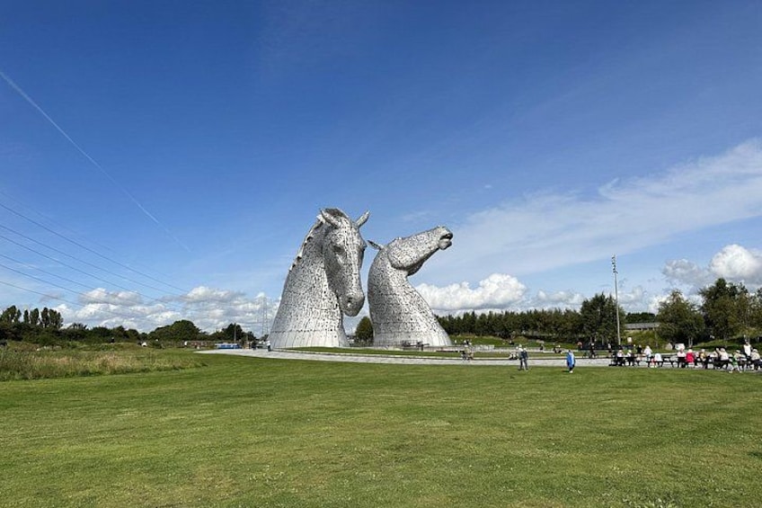 Les Kelpies, deux grandes structures métalliques blanches en forme de chevaux, se dressent sur un ciel bleu dégagé. 2