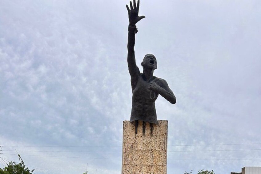 A statue of a person with raised arms on a pedestal. 2