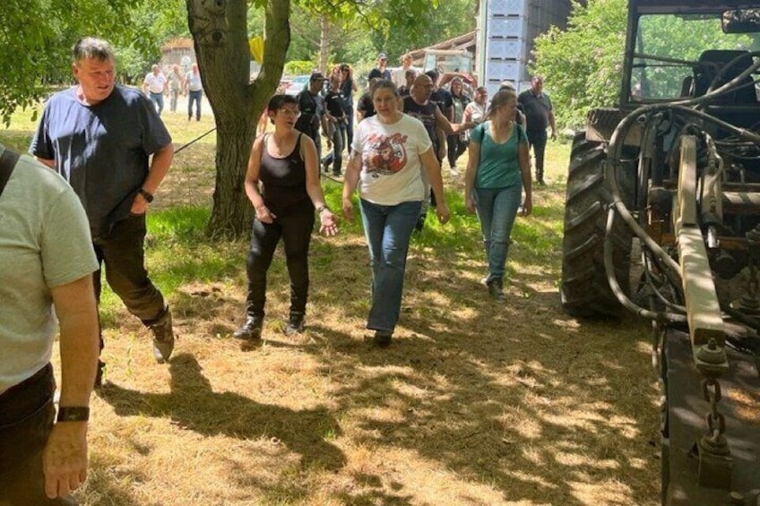 People walking near a tractor in a wooded area. 2