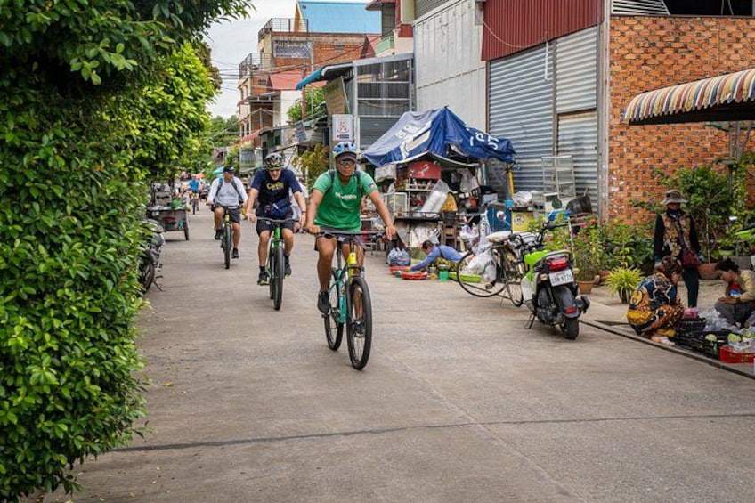 Ciclistas en una calle con comercios y un edificio de ladrillo. 2