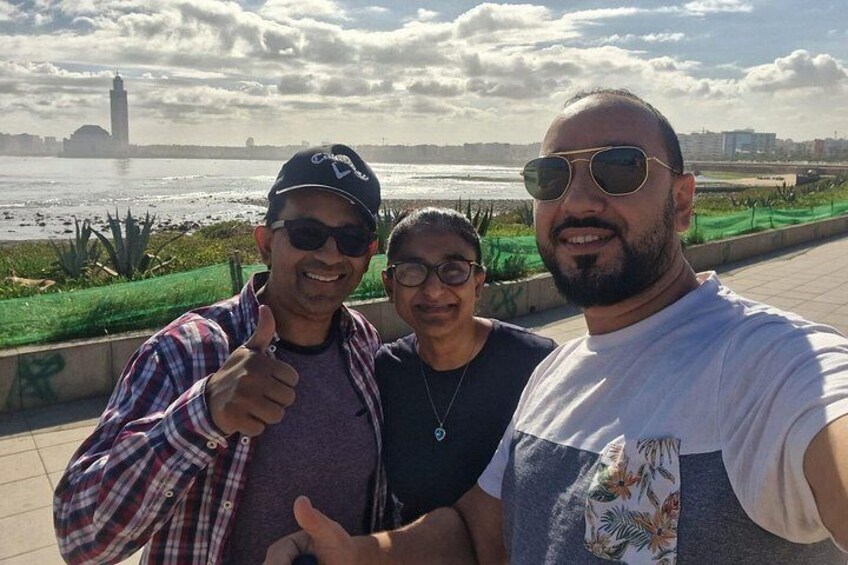 Tres personas tomando una selfie con un río y una torre distante al fondo. 4
