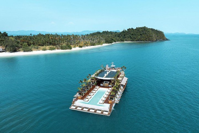 An aerial view of a floating resort with a pool, lounge chairs, and a deck. 1
