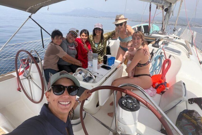 Un grupo de personas en un velero con vista despejada al agua y a la costa distante. 2