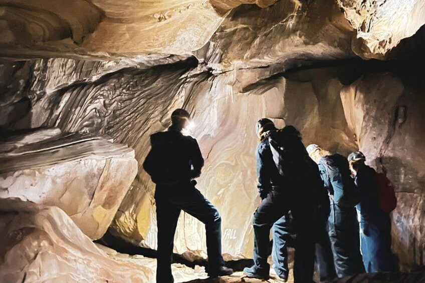A group of people inside a cave with rock formations. 2