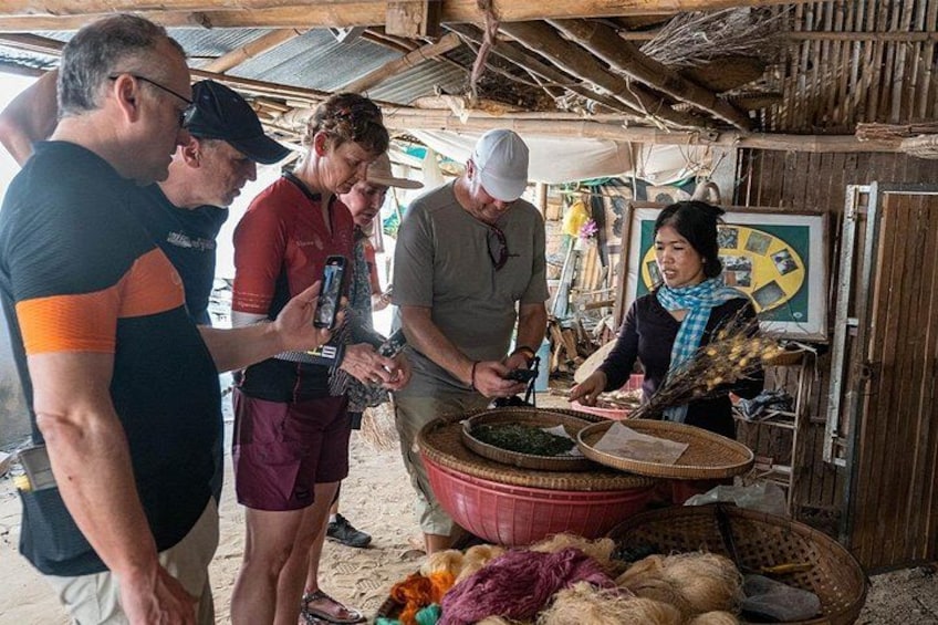 Un grupo de personas en un entorno rural, posiblemente un mercado o taller, con cestas y herramientas sobre una mesa. 5