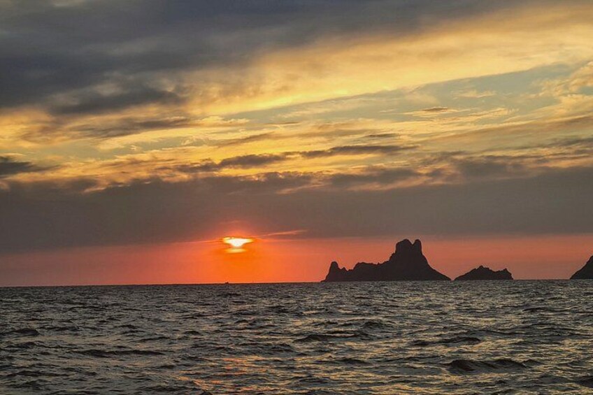 Solnedgang over havet med silhuetter af øer. 1