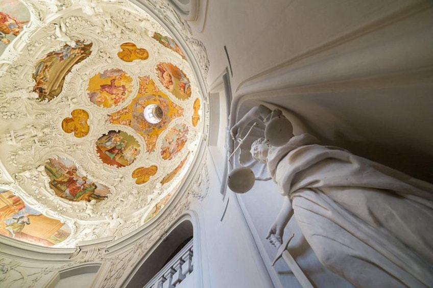Et loft prydet med detaljerede freskomalerier og en statue. 2