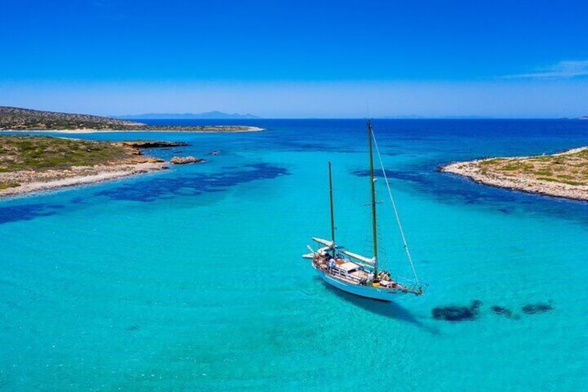 A sailboat in turquoise waters with a clear sky. 1