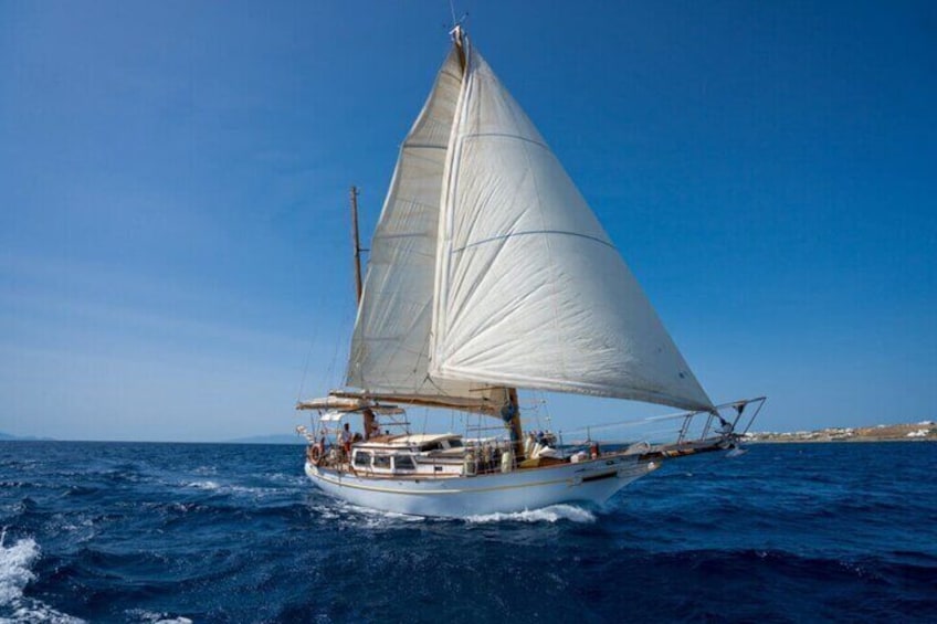 A sailboat with a white sail on the ocean. 2