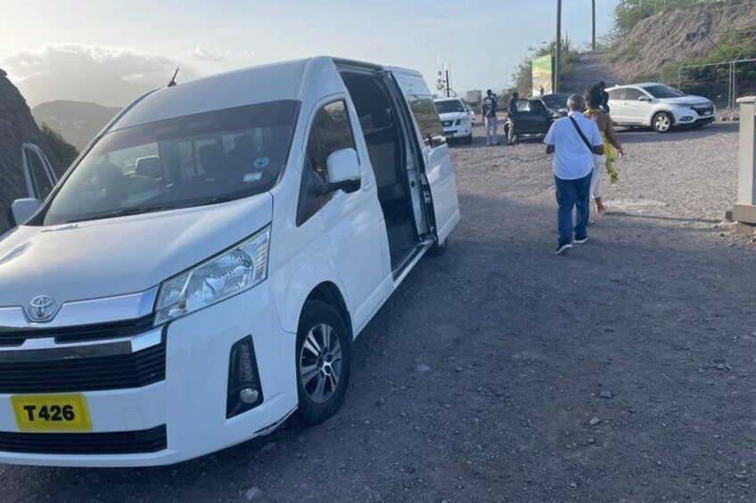Een witte bestelwagen staat geparkeerd op een onverharde weg, kenteken T426. 4