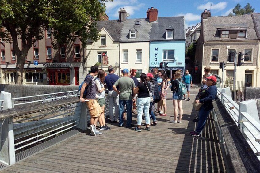 A wooden boardwalk with people standing and walking. 5