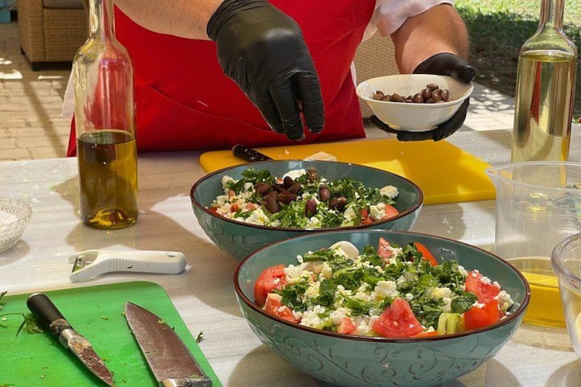 A person preparing a salad with ingredients in bowls, a cutting board, and a knife on a table. 3