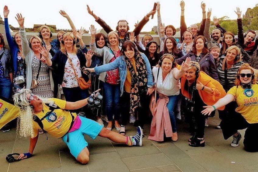 Een groep mensen die buiten een foto maakt, met iemand die op de grond ligt. 2
