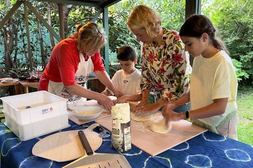 People preparing food outdoors with a table, a cutting board, and a bowl. 1