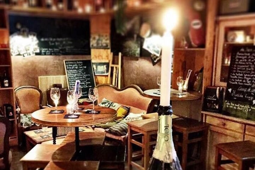 A cozy restaurant interior with wooden furniture, candles, and chalkboard menus. 4