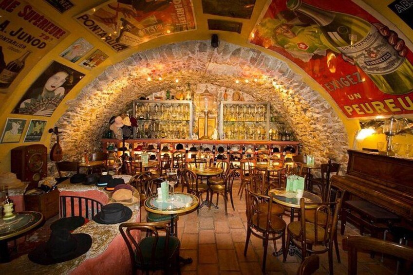 A bar with a stone archway, wooden furniture, and various bottles and glasses. 5