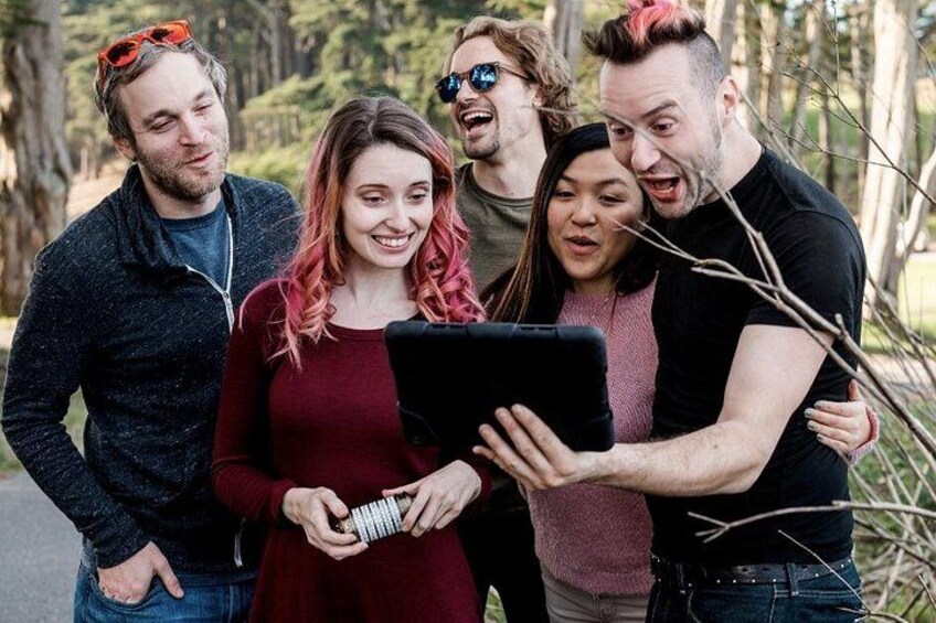 A group of people outdoors, some holding a tablet. 3