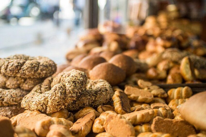 A variety of baked goods, including bread and cookies, displayed at a market. 3