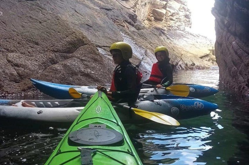 Kayaks in a narrow waterway with rocky walls. 5