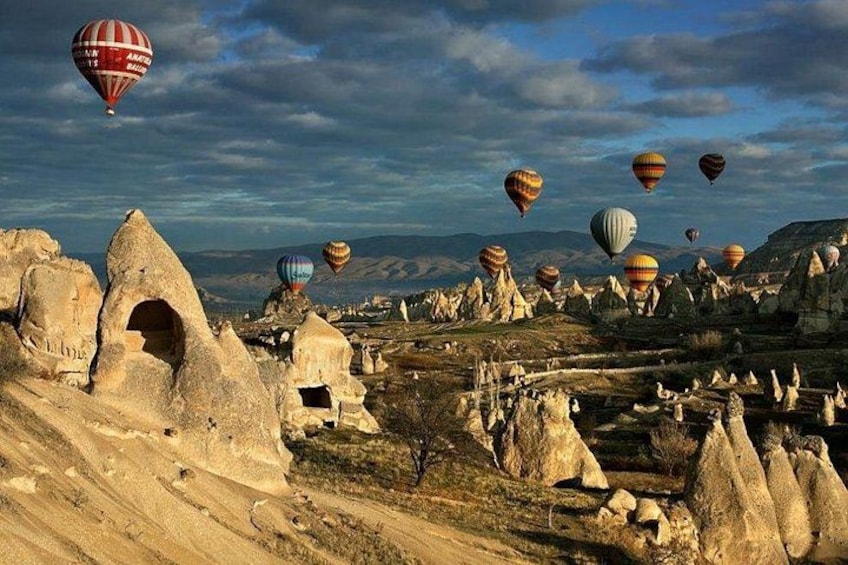 Eine Landschaft mit außergewöhnlichen Felsformationen und Heißluftballons. 1
