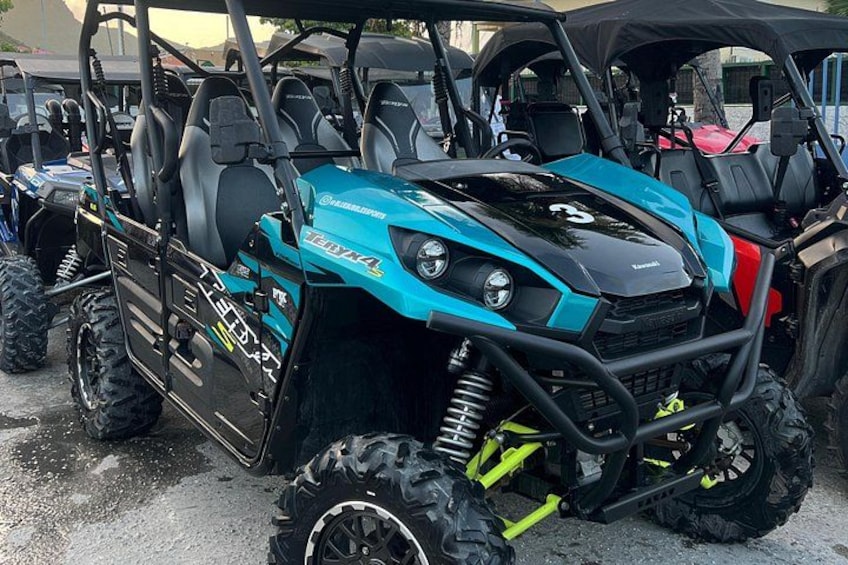 A blue and black ATV with a number 3 on the front, parked among other ATVs. 5