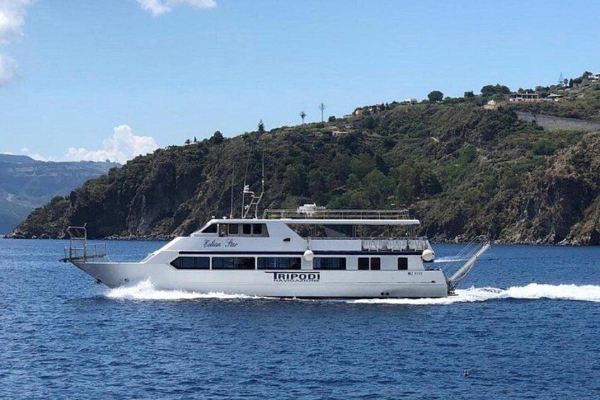 Eine weiße Yacht namens 'Eldorado' auf ruhiger See mit einer hügeligen Küstenlinie im Hintergrund. 3