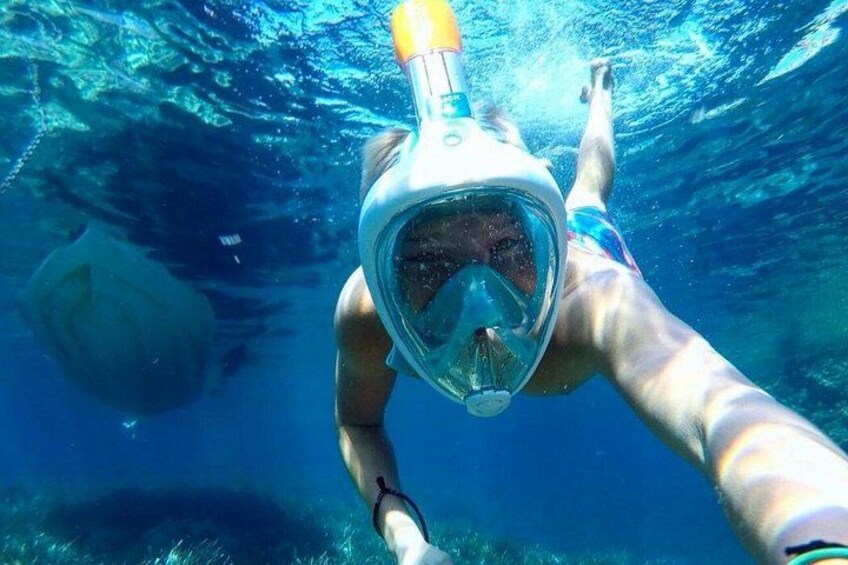 En person som snorklar under vattnet med hjälp av en snorkel och en dykmask. 2