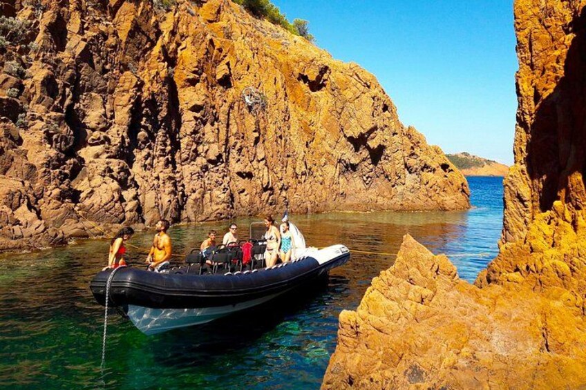 A boat with people on a rocky coastline. 2