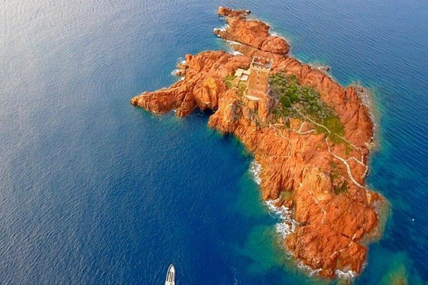 An aerial view of a rugged island with a castle, surrounded by deep blue waters. 2