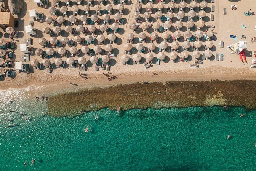 Luchtbeeld van een strand met veel parasols en ligbedden. 2