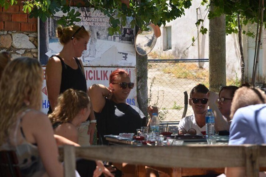 People sitting at an outdoor table with a banner in the background. 4