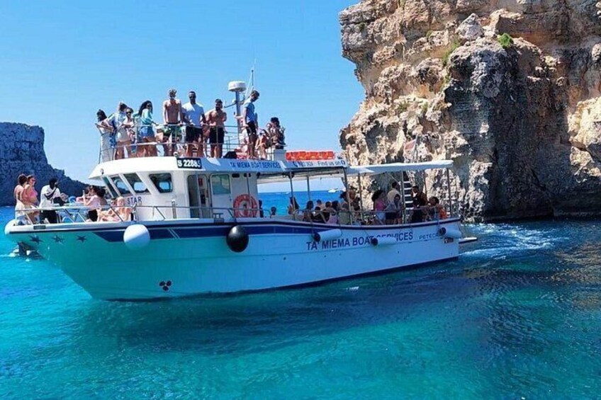 A boat with people on it near a rocky coastline. 4