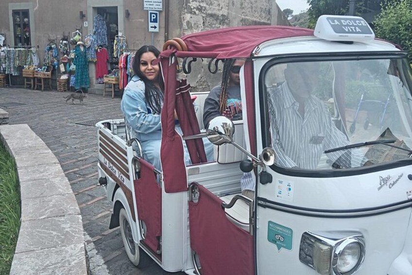 A vintage car with a red canopy parked on a cobblestone street. 5