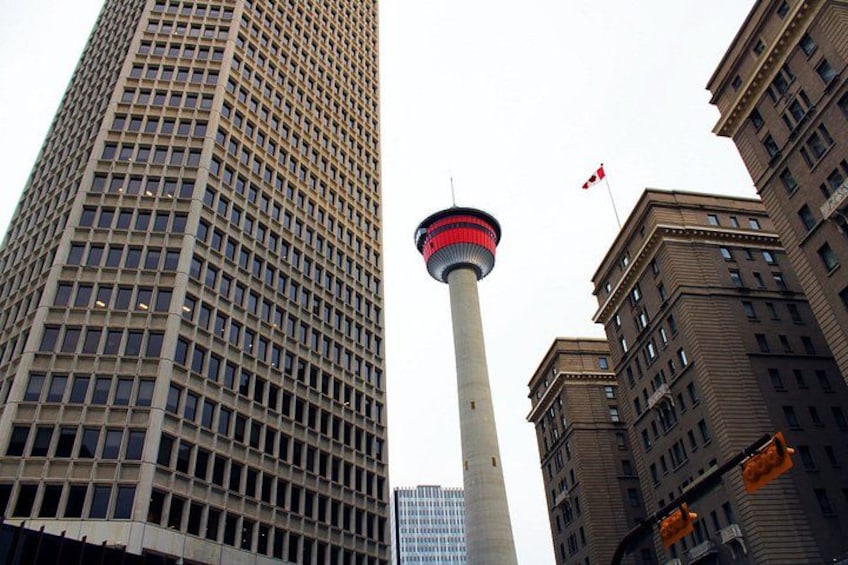 A tall building, a tower with a red and white stripe, and another building with a flag. 2
