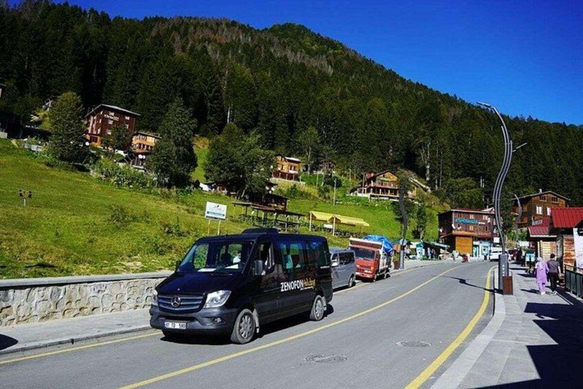 A road with vehicles, a mountain backdrop, and buildings. 2