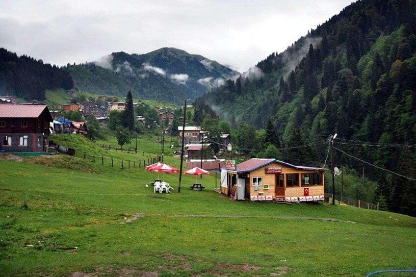 A mountainous landscape with a small village, houses, and a red-roofed building. 3