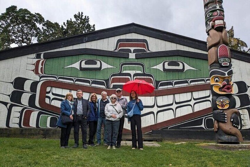 A mural of a totem with a group of people standing in front of it. 4