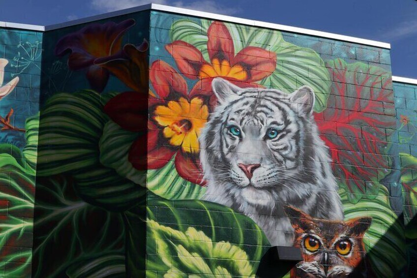 A mural with a tiger, flowers, and an owl. 3